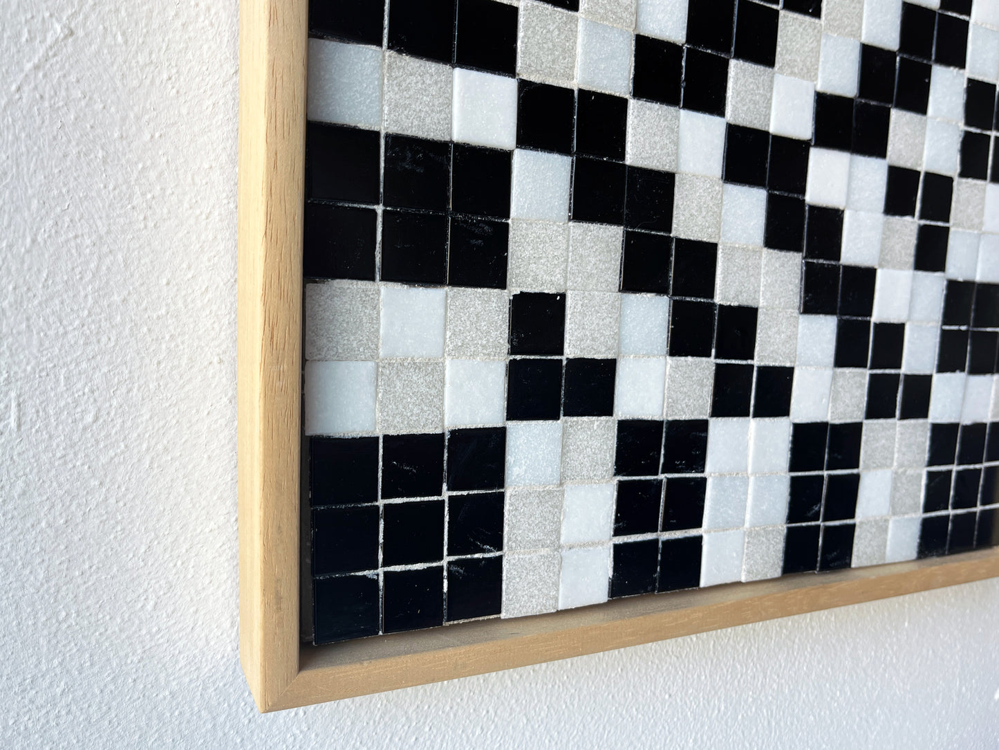 Zwart wit mozaïek kunstwerk in houten lijst als voorbeeld van kunst door Guido de Boer