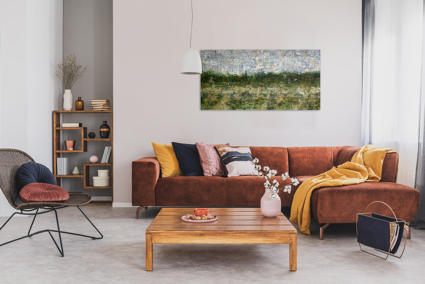 Landschap schilderij van Elise Eekhout boven een gezellige bruine bank in een moderne woonkamer