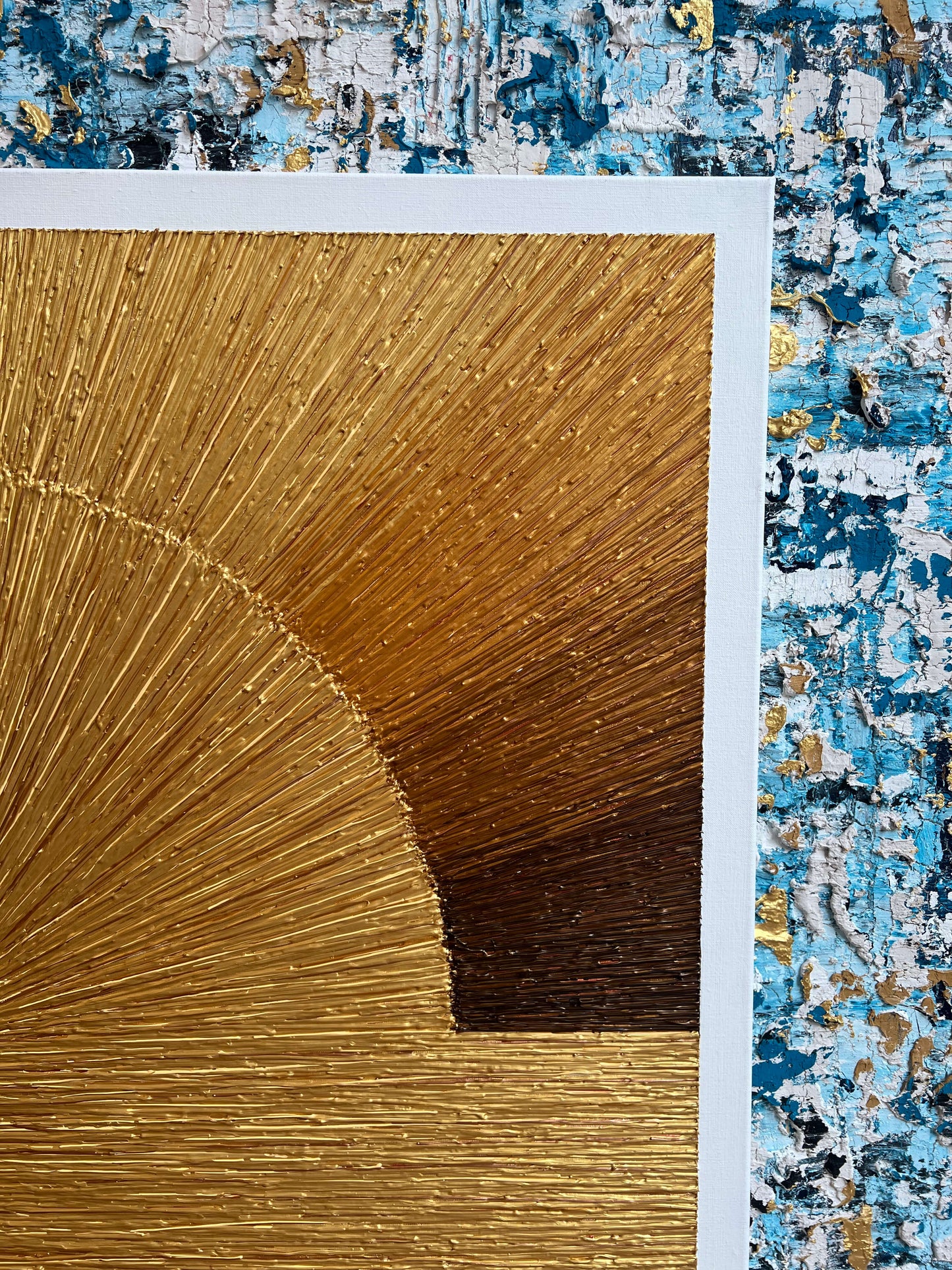 Modern schilderij zonsondergang in warme gouden tinten met textuur geplaatst op blauwe muur