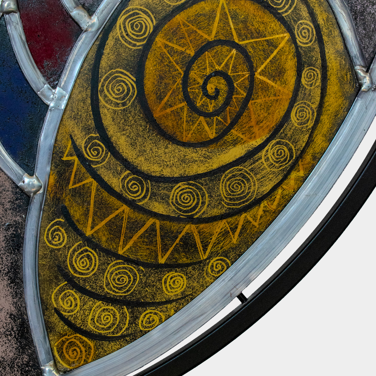 Detail van Paard & Vogel glaskunst met gele en zwarte spiraalvormige patronen in een metalen frame