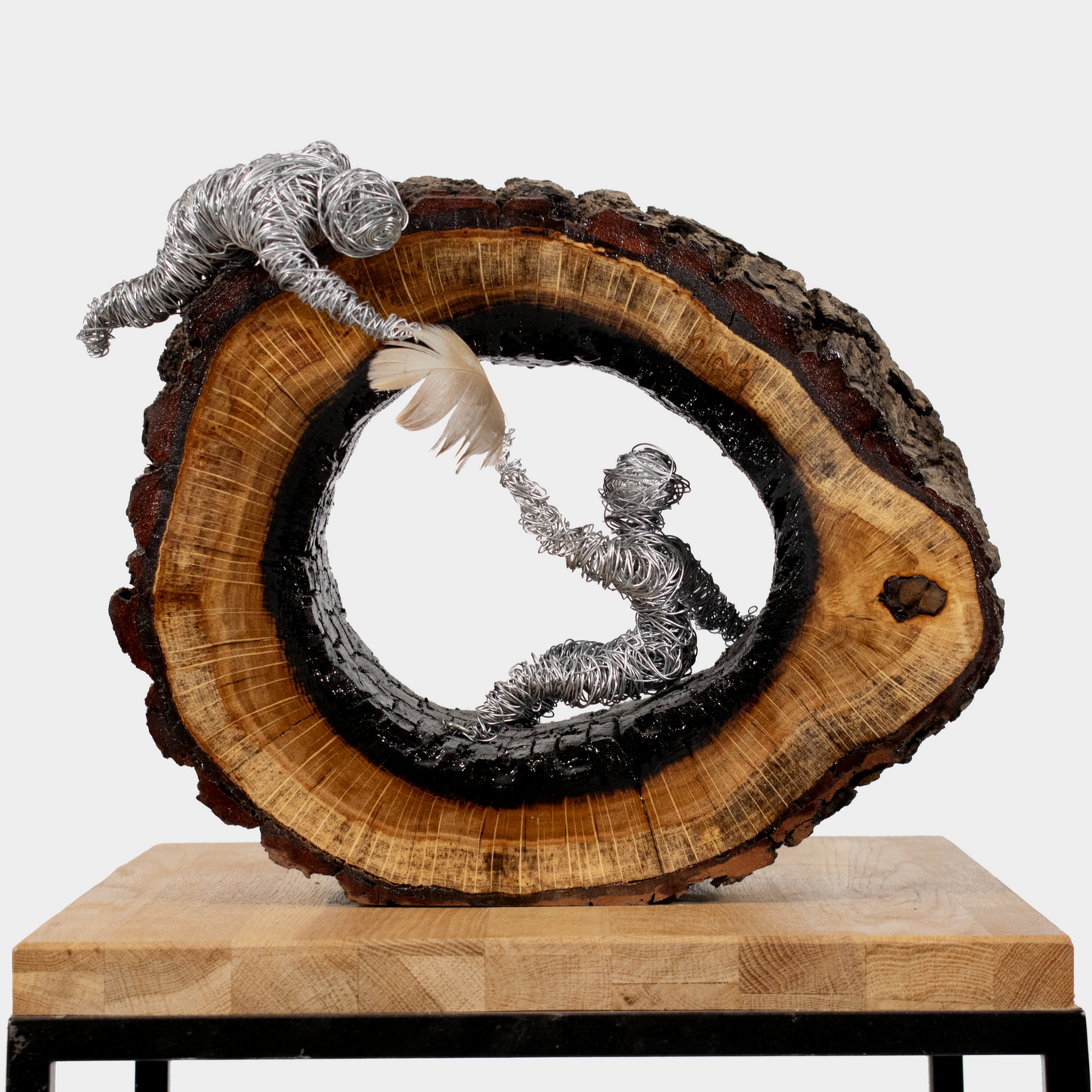 Uniek handgemaakt kunstwerk van Semra Heydari met metalen figuren in een houten holle stam
