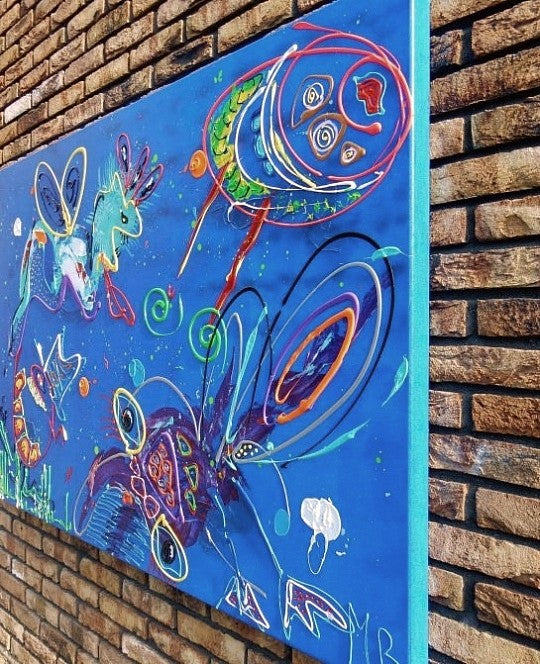 Uniek kunstwerk kopen van kleurrijk abstract schilderij door Art by Marieke Brouwers aan bakstenen muur
