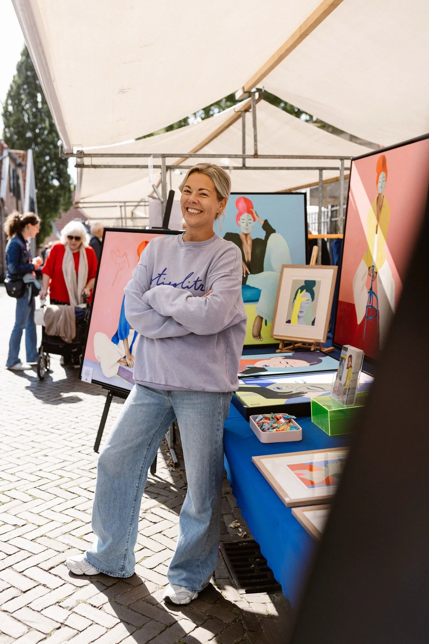 Kunstenares met Stand op de Markt met Schilderijen van Loes Kamphuis en Creatieve Werken