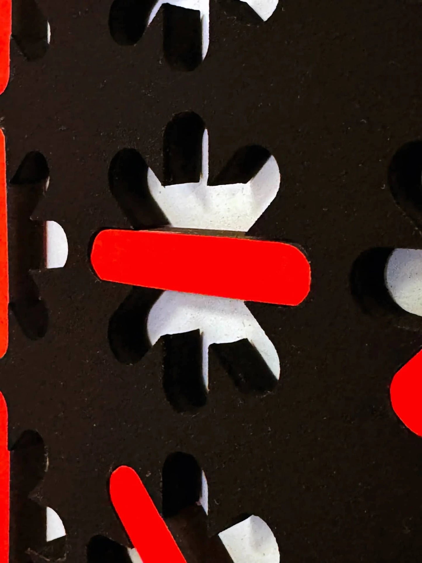 Detail van een abstract kunstobject van Rob Stolte met zwarte en rode vormen en cut-outs