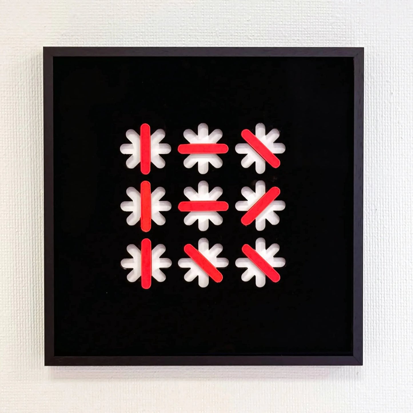 Abstract kunstobject van Rob Stolte met witte en rode vormen op een zwarte achtergrond