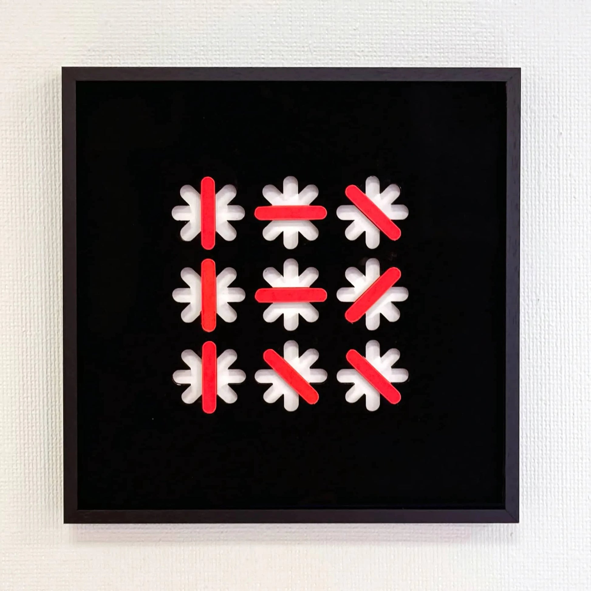 Abstract kunstobject van Rob Stolte met witte en rode vormen op een zwarte achtergrond