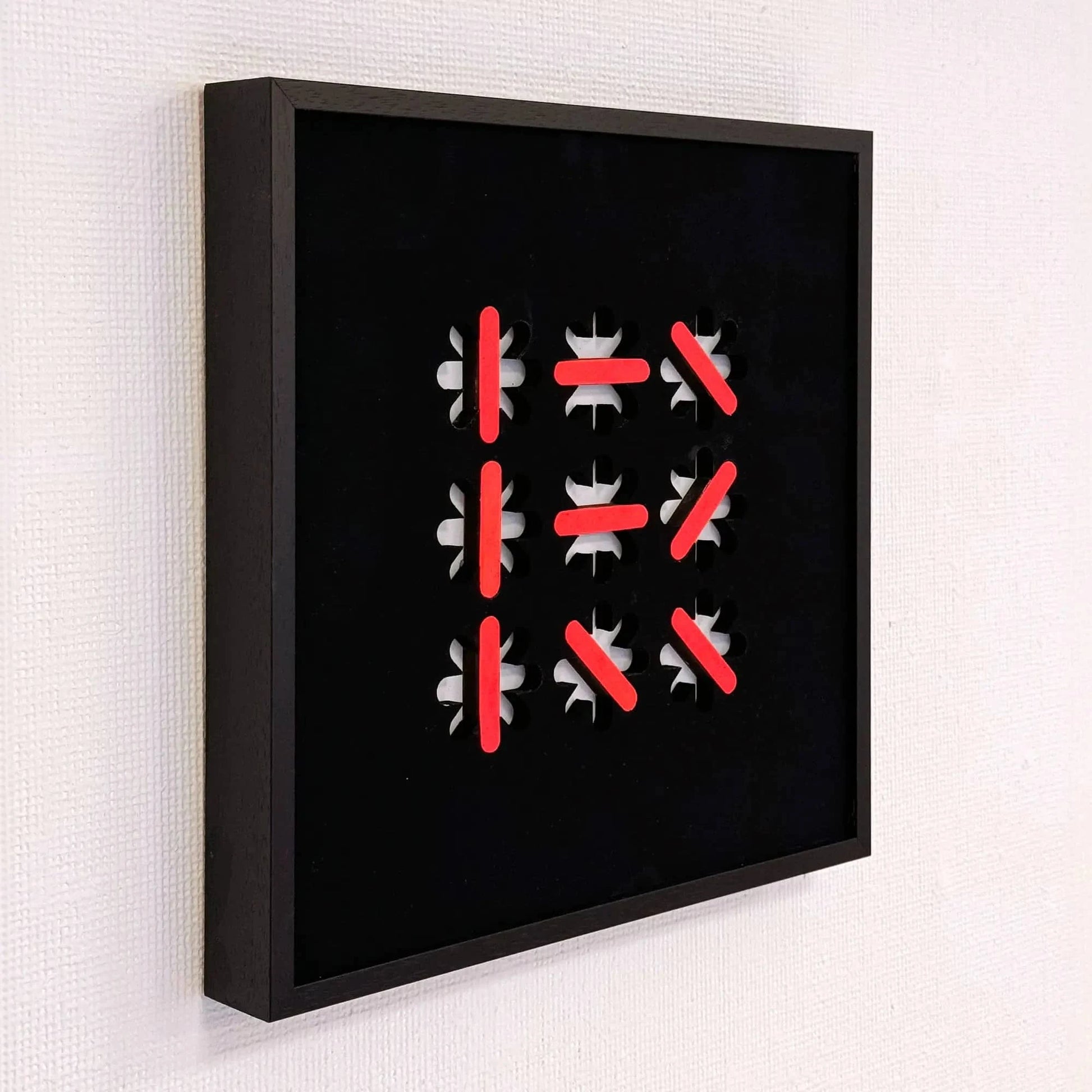 Abstract kunstobject van Rob Stolte met zwart kader en opvallende rode en witte elementen