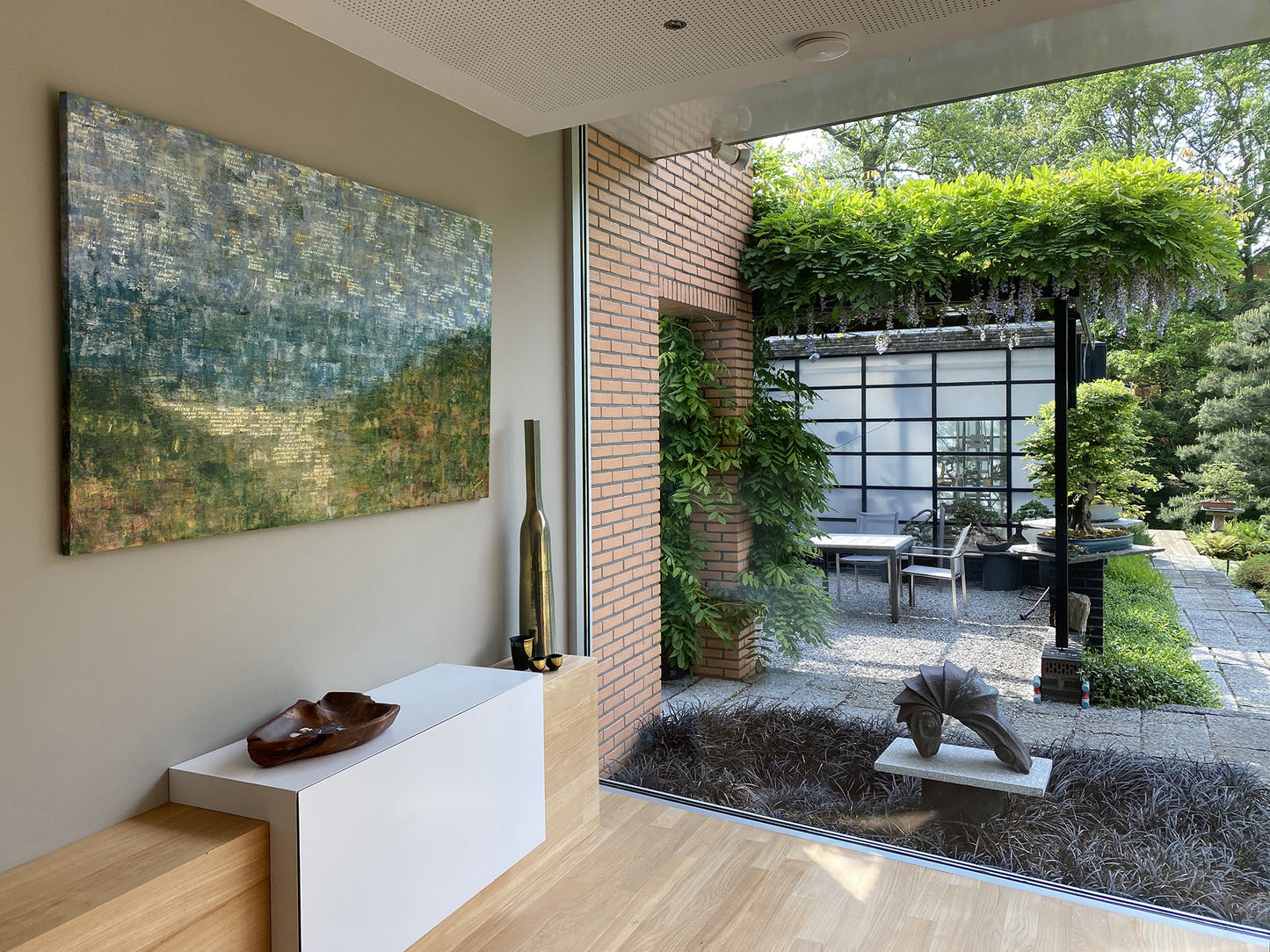 Abstract landschap schilderij van Elise Eekhout dat een rustige groene omgeving in een moderne woonkamer toont