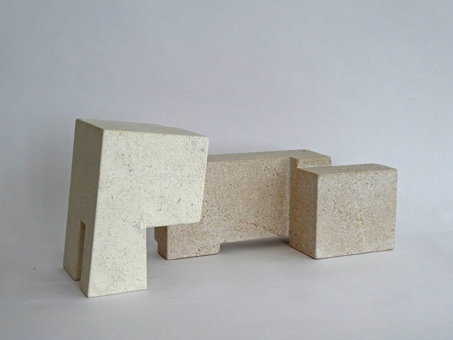 Abstracte sculptuur van natuursteen met geometrische vormen en een neutrale kleurstelling