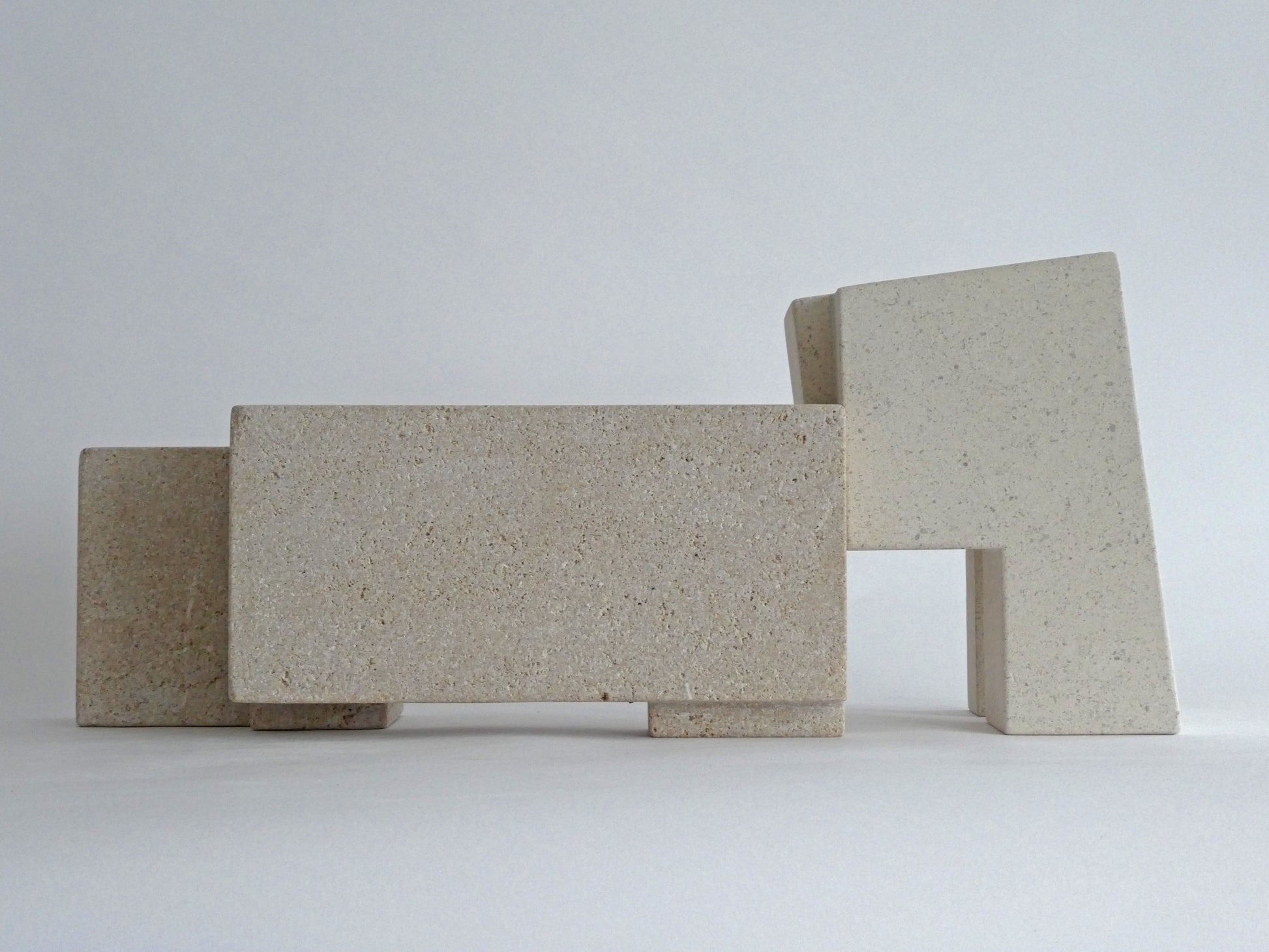 Abstracte sculptuur van lichtgekleurde stenen met geometrische vormen en een moderne uitstraling