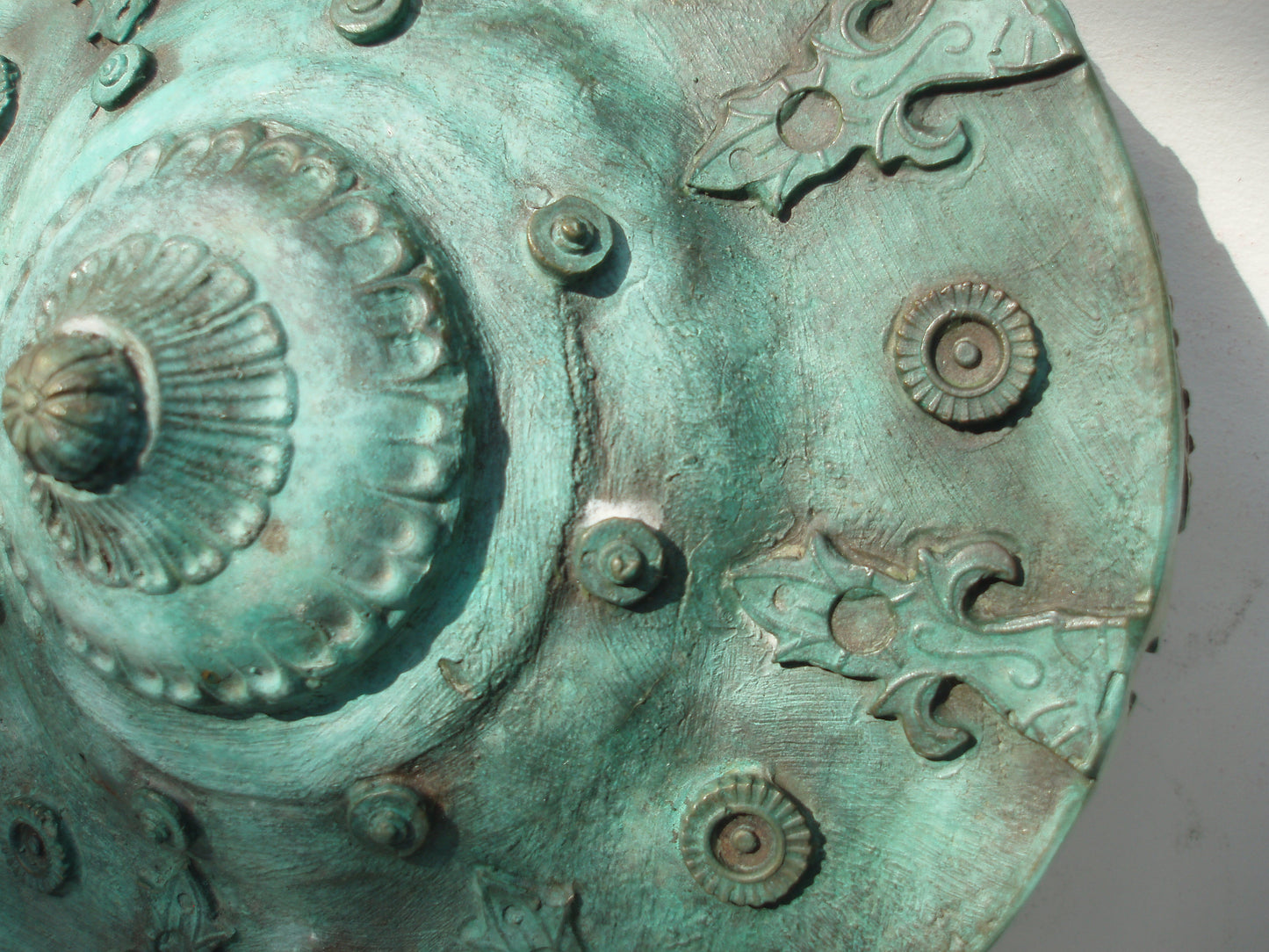 Detail van een bronzen carrousel sculptuur met complexe ontwerpen en een verouderde afwerking