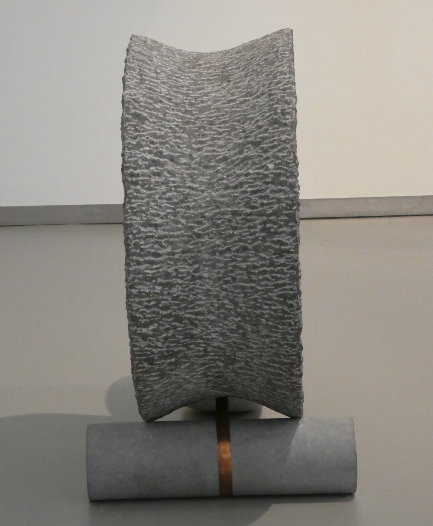 Moderne hardsteen sculptuur met unieke textuur en metalen voet voor eigentijdse kunstliefhebbers