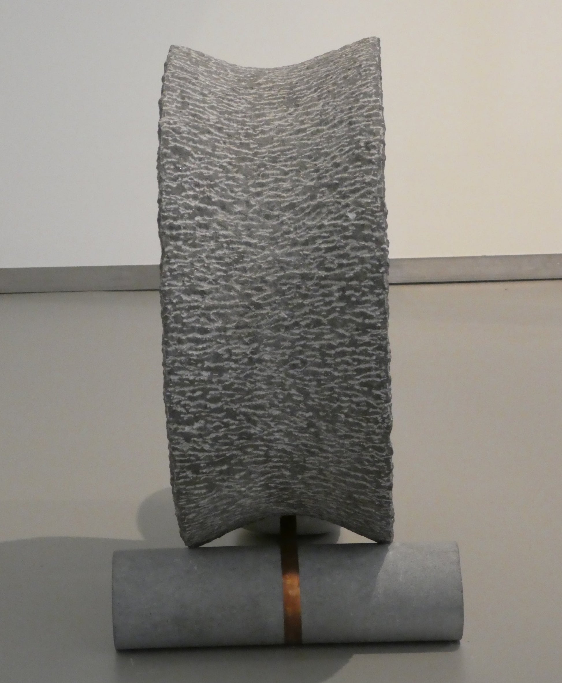 Moderne hardsteen sculptuur met unieke textuur en metalen voet voor eigentijdse kunstliefhebbers