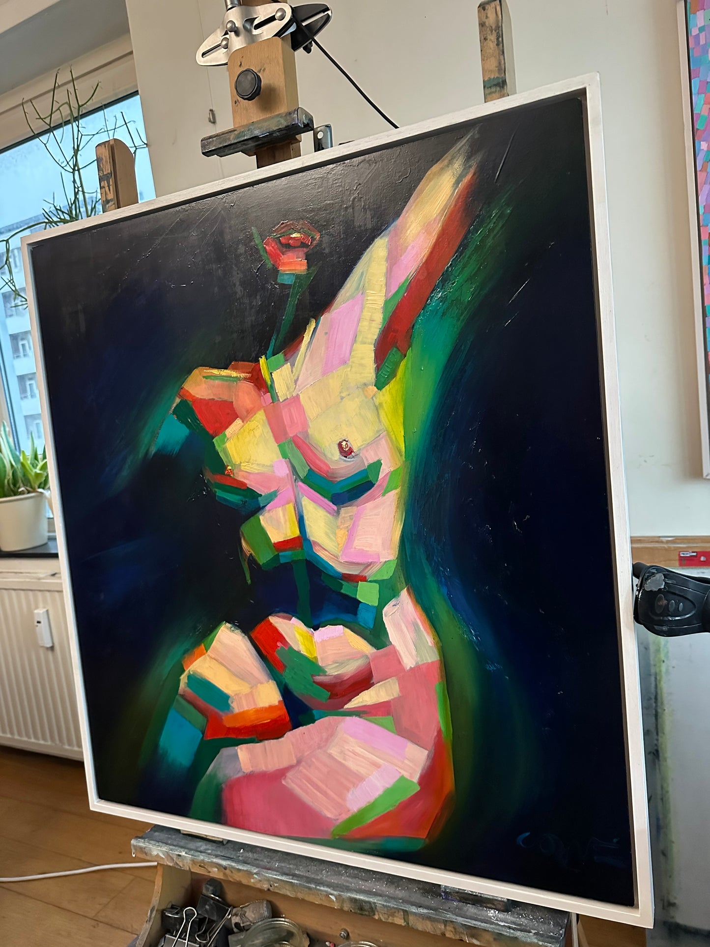 Kubistisch naakt schilderij van Corné Akkers in levendige kleuren, weergegeven op een schildersezel