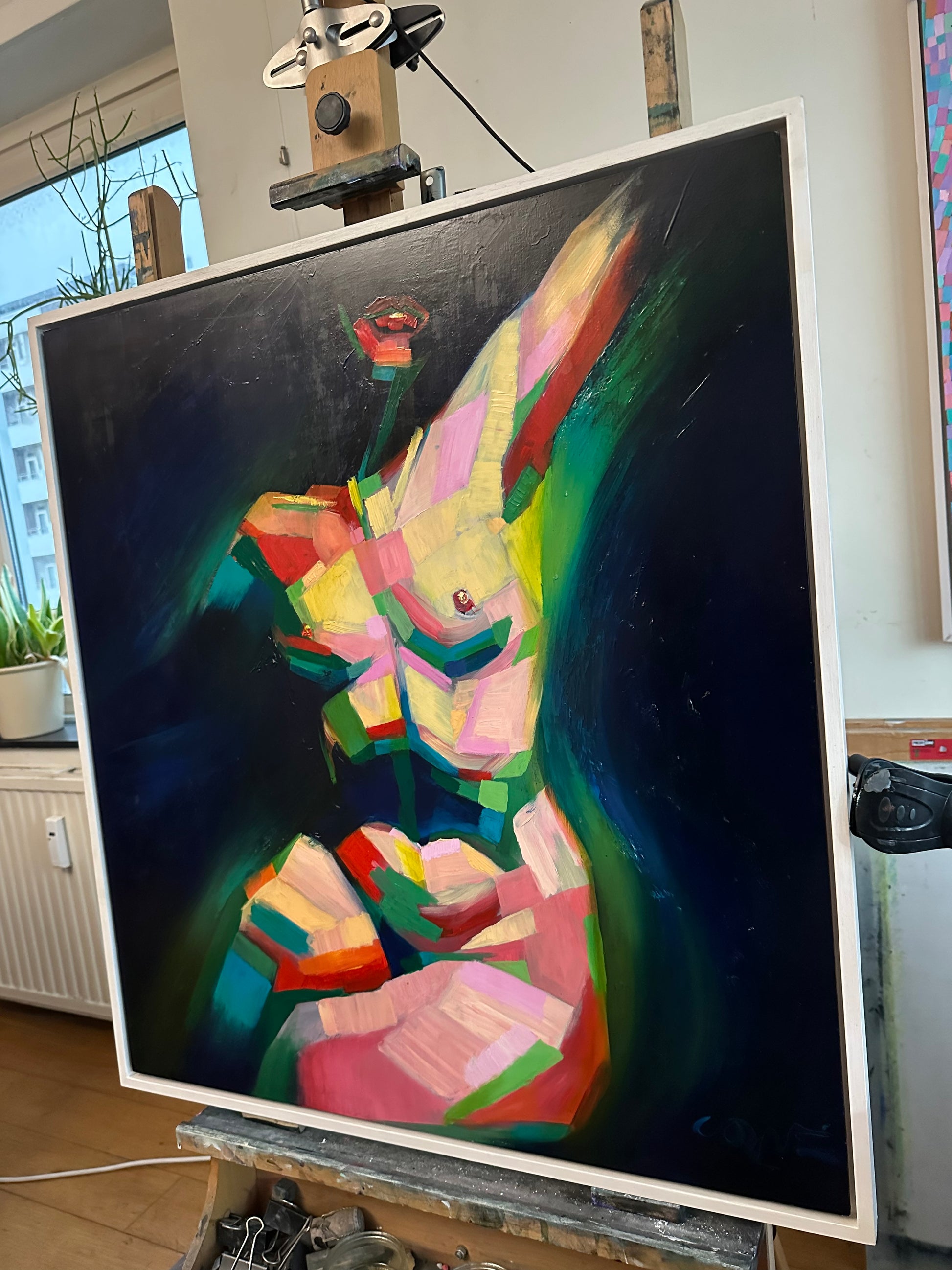 Kubistisch naakt schilderij van Corné Akkers in levendige kleuren, weergegeven op een schildersezel