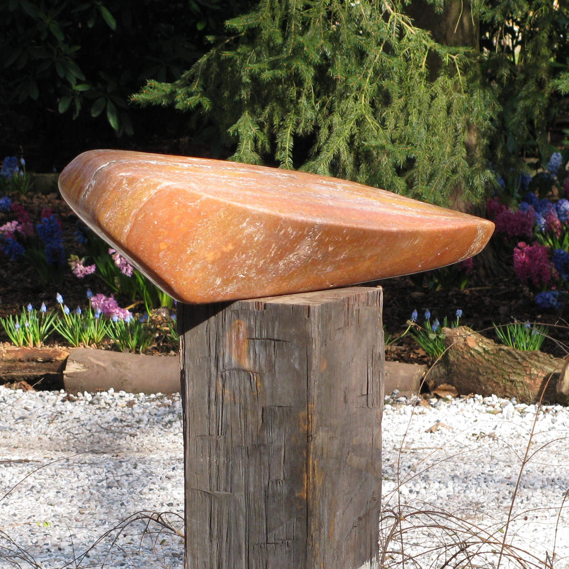 Unieke travertijn sculptuur op een houten basis, perfect voor tuin of interieurdecoratie