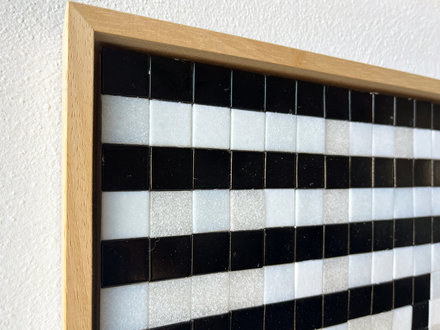 Detail van een uniek handgemaakt kunstwerk van Guido de Boer met zwart-witte mozaïektegels en houten lijst