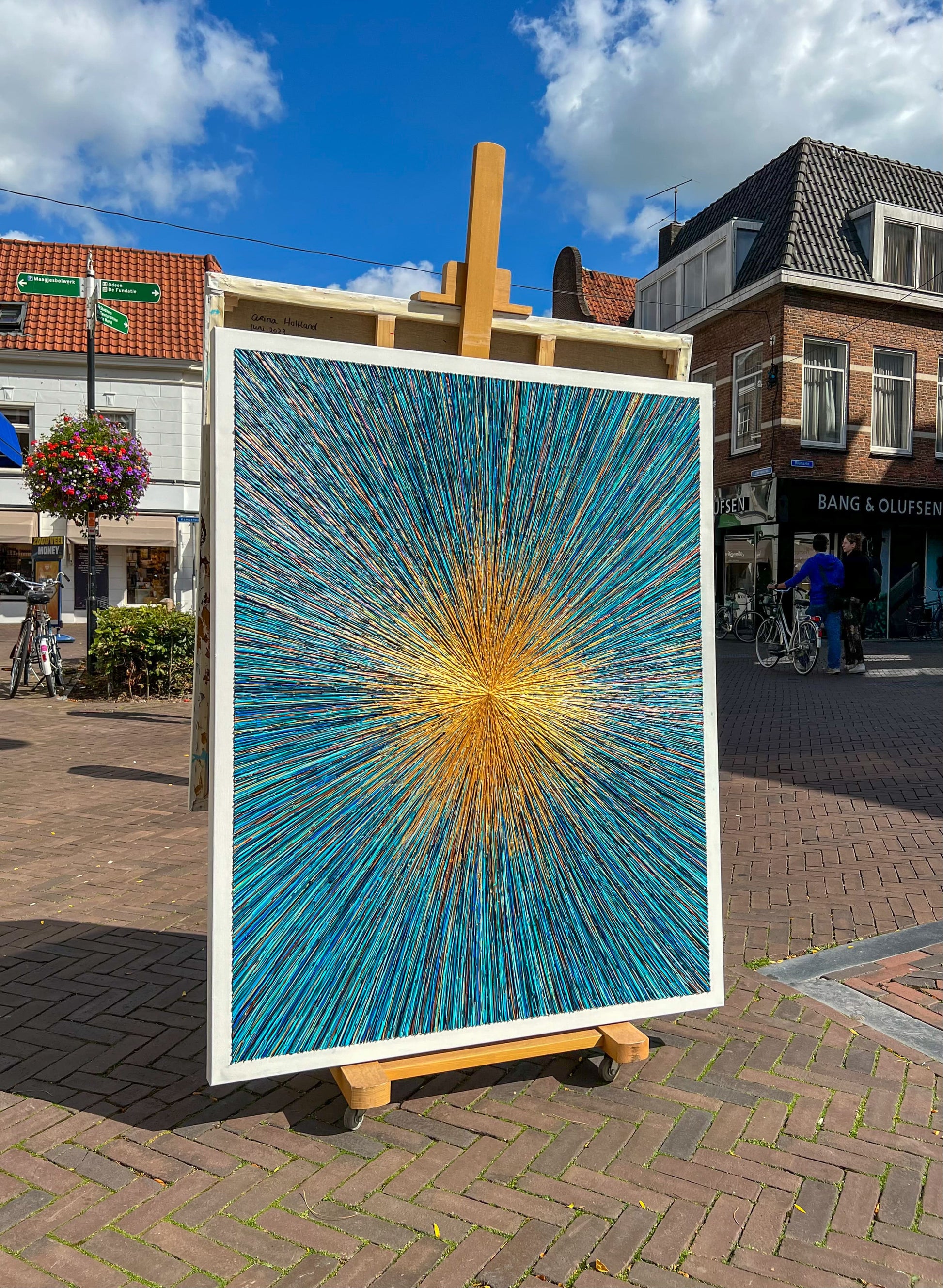 Uniek kunstwerk Azure schilderij met blauwe en gele straalvormen tentoongesteld in buitenruimte van Atelier58